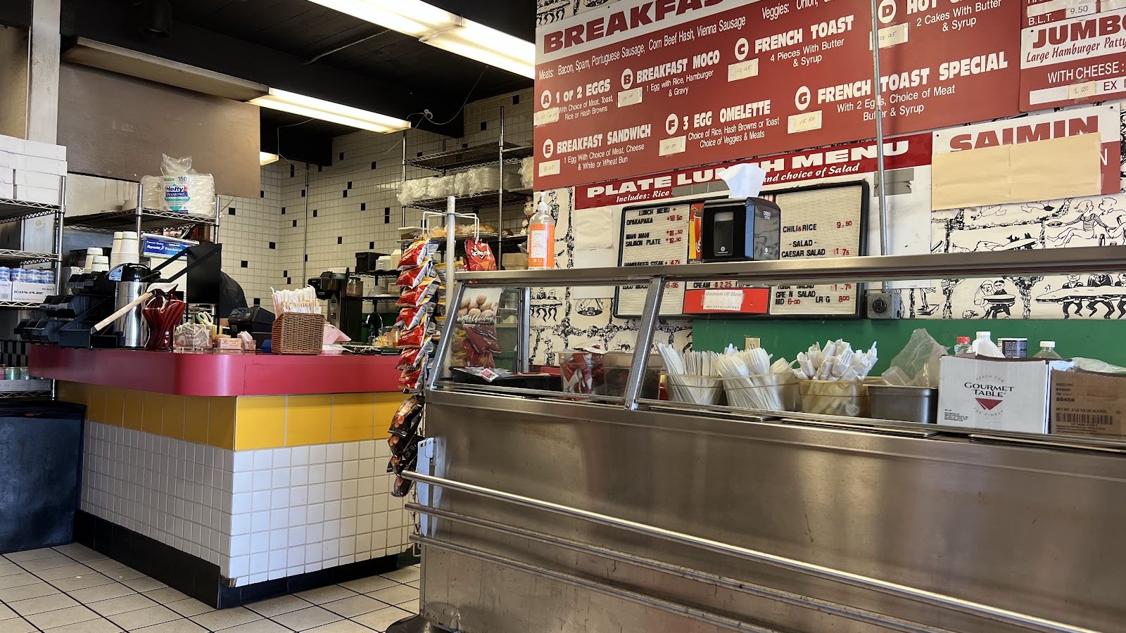 Inside Home Maid Cafe — the counter and hand-written menu board.