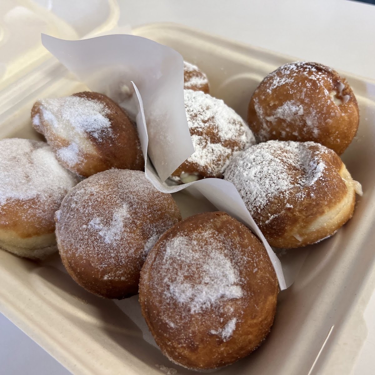 A box of fresh malasadas dusted in sugar at Home Maid Cafe.